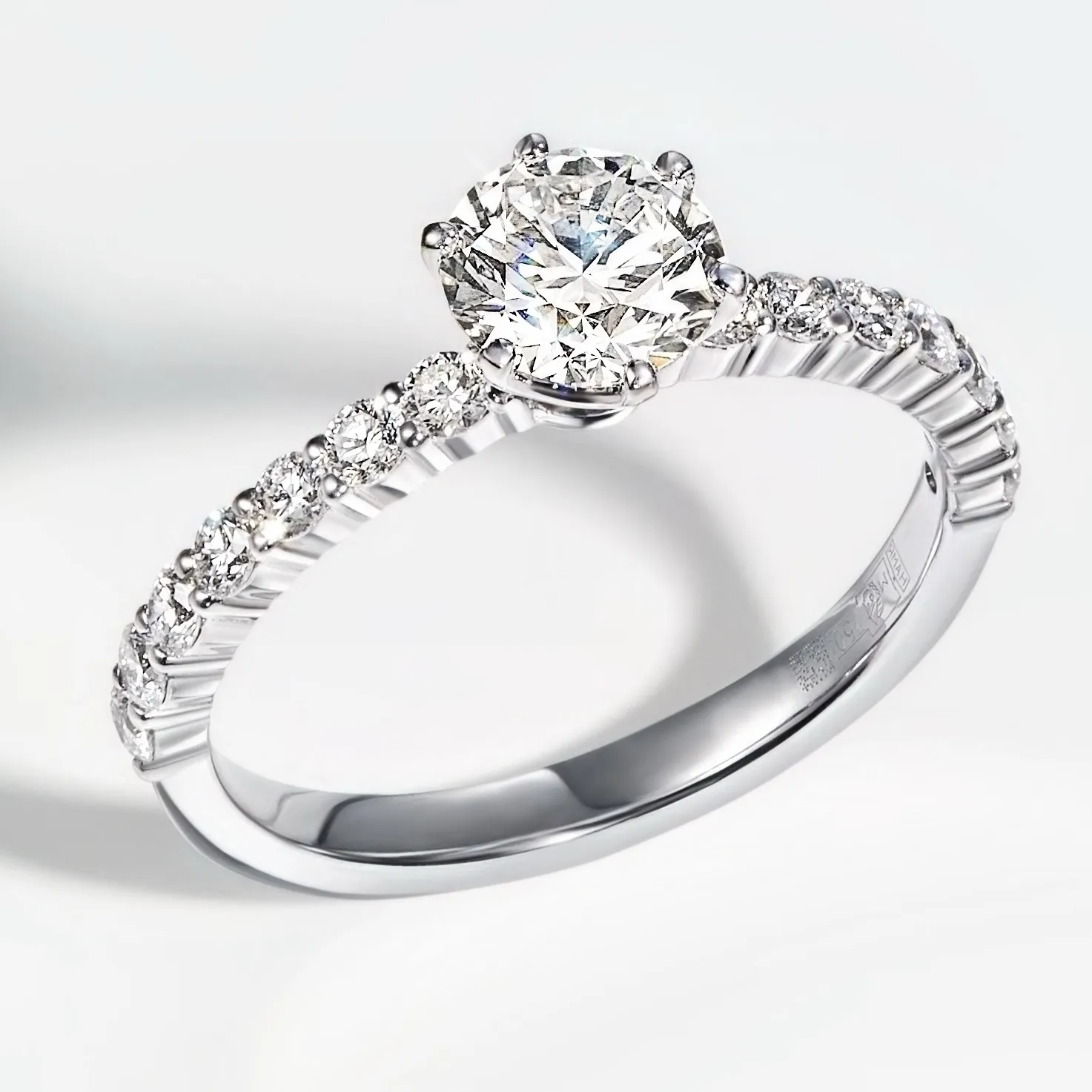 Женское кольцо из белого золота с крупным бриллиантом и бриллиантовой дорожкой