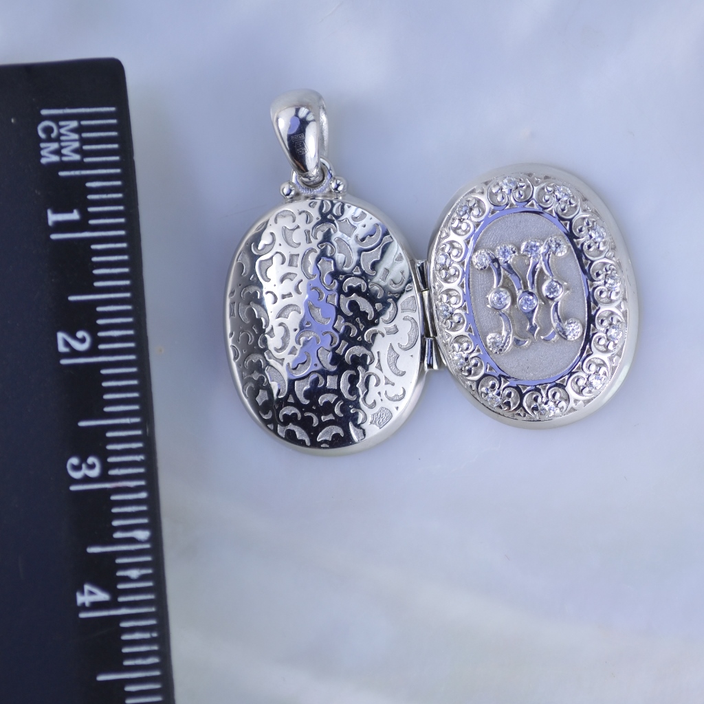 Отрывающийся серебряный медальон с фотографиями родителей внутри и инициалами в виде монограммы (Вес: 8,6 гр.)