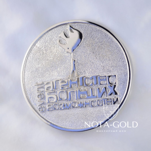 Золотая медаль из белого золота с гравировкой и логотипом агентства по организации праздников (Вес: 27 гр.)