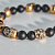 Золотой браслет с черепами и бусинами из чёрного оникса (цена за грамм)